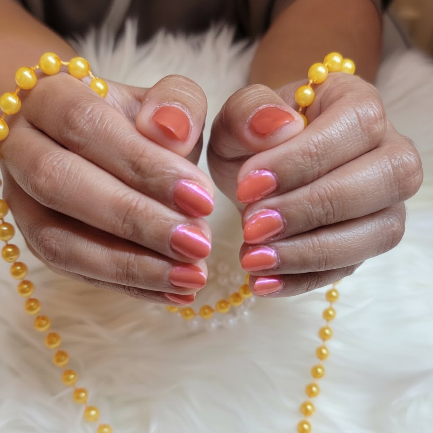 Coral pink shimmer gel manicure with golden pearls