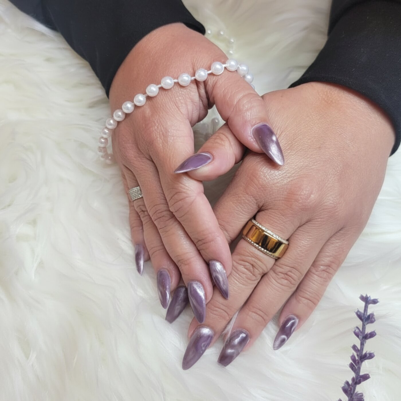 Purple cat eye almond stiletto nails with pearl bracelet